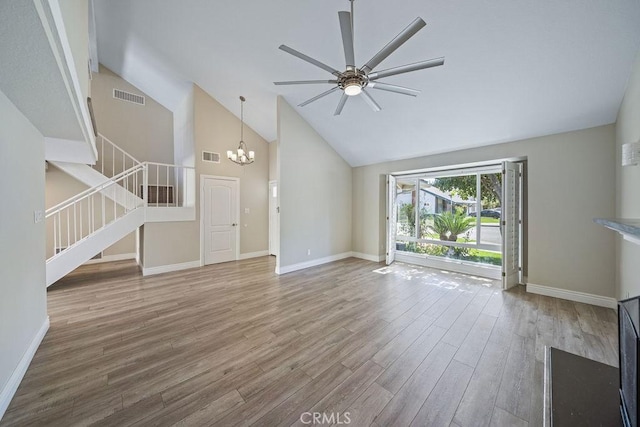 unfurnished living room featuring stairs, visible vents, high vaulted ceiling, and wood finished floors