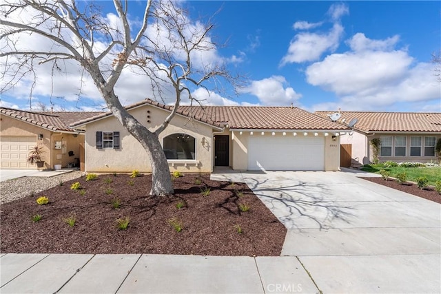 mediterranean / spanish-style house with a tiled roof, an attached garage, driveway, and stucco siding