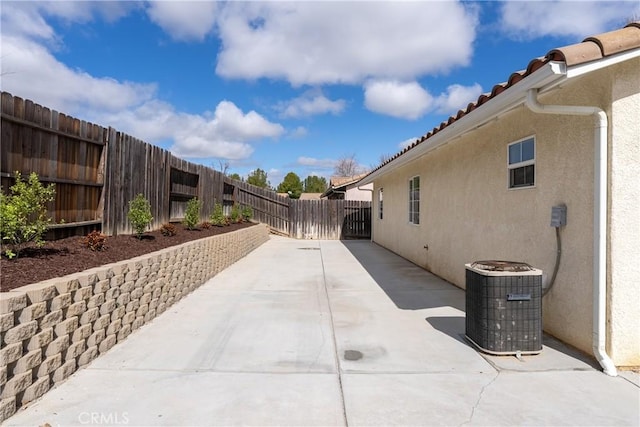 exterior space featuring cooling unit, a fenced backyard, a patio, and stucco siding