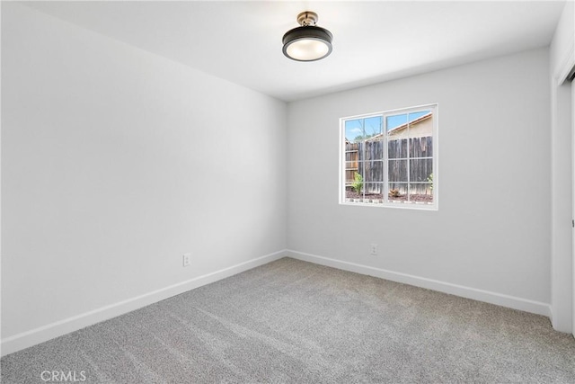 carpeted spare room with baseboards