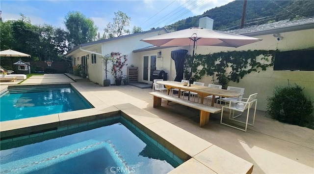 pool with area for grilling, outdoor dining area, and a patio