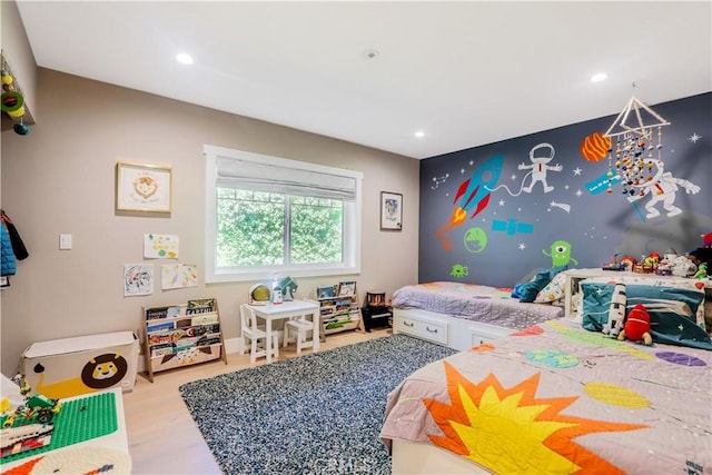 bedroom featuring recessed lighting, wood finished floors, and an accent wall