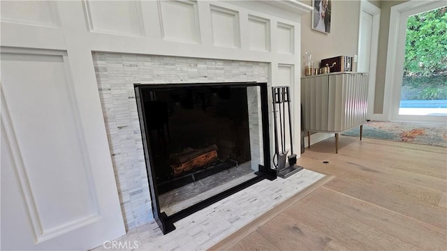 interior details featuring a fireplace with flush hearth and wood finished floors