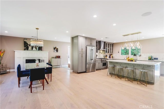 dining room featuring light wood finished floors, baseboards, a chandelier, recessed lighting, and a fireplace