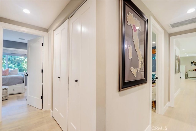 hallway featuring light wood-style flooring, recessed lighting, and visible vents