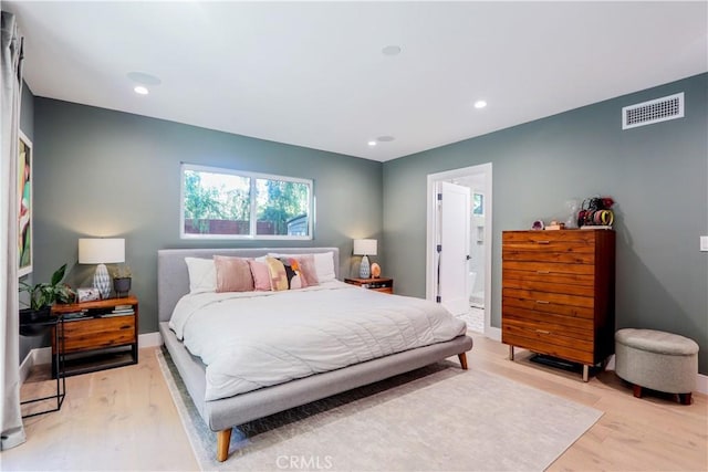 bedroom with visible vents, baseboards, light wood-type flooring, recessed lighting, and ensuite bath