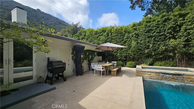 view of patio featuring grilling area, an in ground hot tub, outdoor dining space, and an outdoor pool