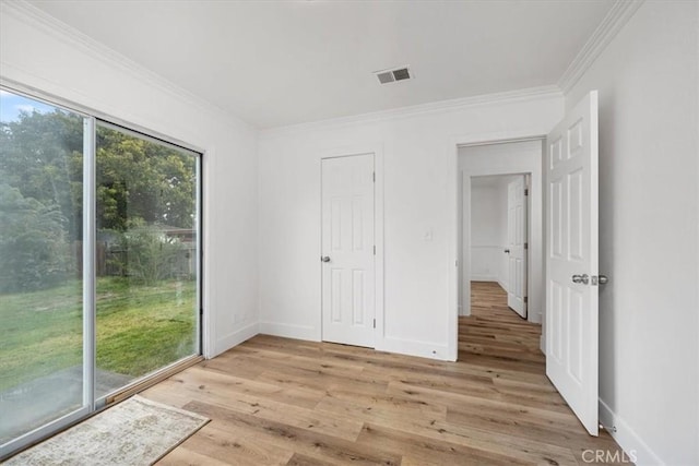 unfurnished room featuring baseboards, ornamental molding, visible vents, and light wood-style floors