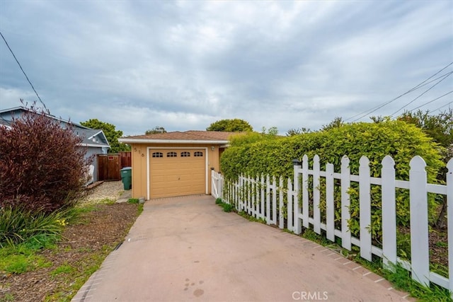 garage with driveway and fence