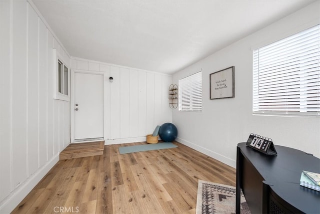 exercise room with light wood-style floors and baseboards