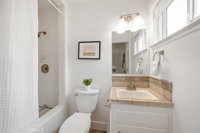 bathroom with tiled shower / bath, vanity, and toilet