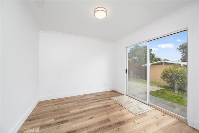 empty room with crown molding, baseboards, and wood finished floors