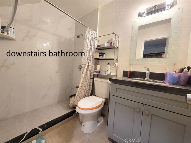 full bath featuring a textured wall, a stall shower, vanity, and toilet