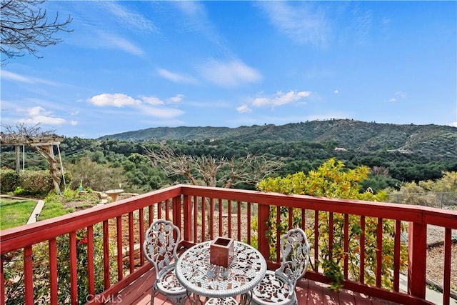 wooden terrace featuring a mountain view and a wooded view