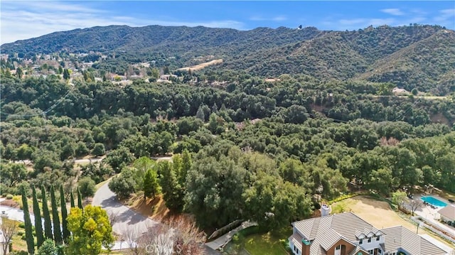 aerial view featuring a forest view and a mountain view