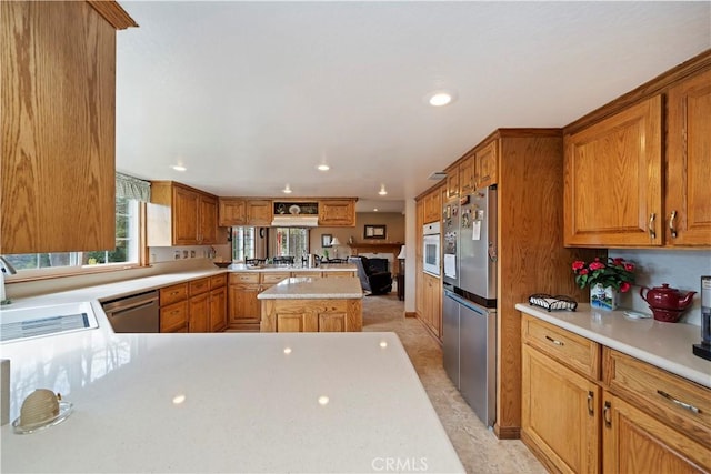 kitchen with dishwasher, a peninsula, light countertops, a sink, and recessed lighting