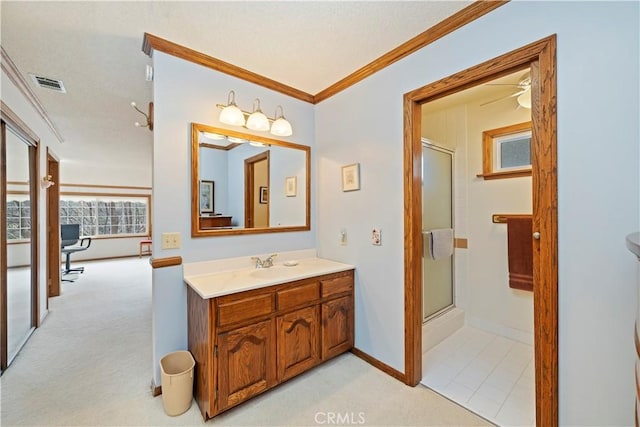 full bath with crown molding, visible vents, a shower with shower door, vanity, and baseboards