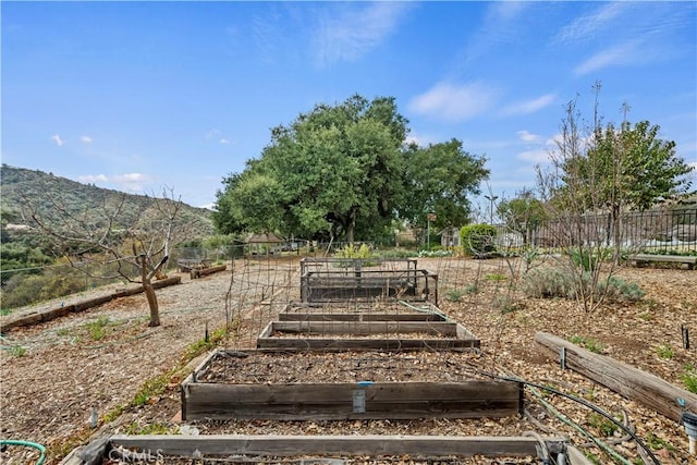 view of yard with a garden, fence, and a mountain view