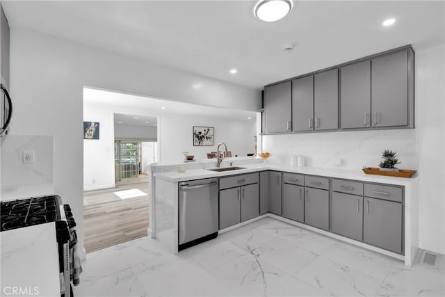 kitchen featuring a sink, marble finish floor, appliances with stainless steel finishes, and gray cabinetry