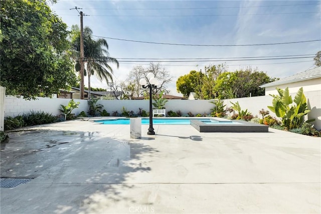 view of pool featuring a fenced in pool, an in ground hot tub, a fenced backyard, and a patio area