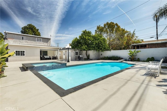 view of pool featuring a patio area, a pool with connected hot tub, a fenced backyard, and a diving board