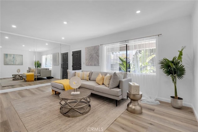 living room with recessed lighting, light wood-type flooring, and a wealth of natural light