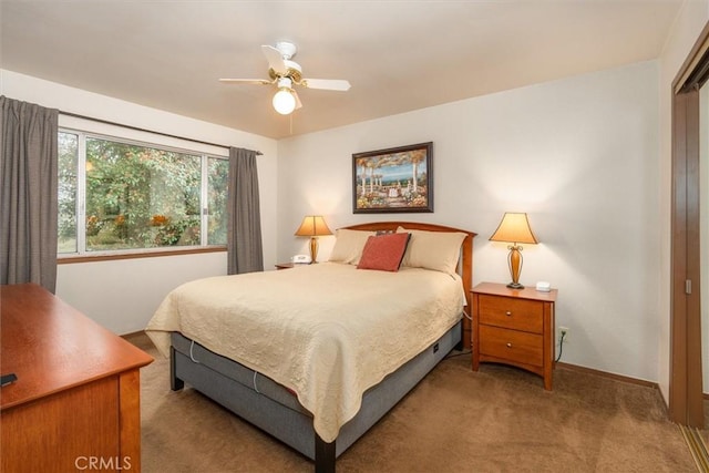 carpeted bedroom with ceiling fan and baseboards