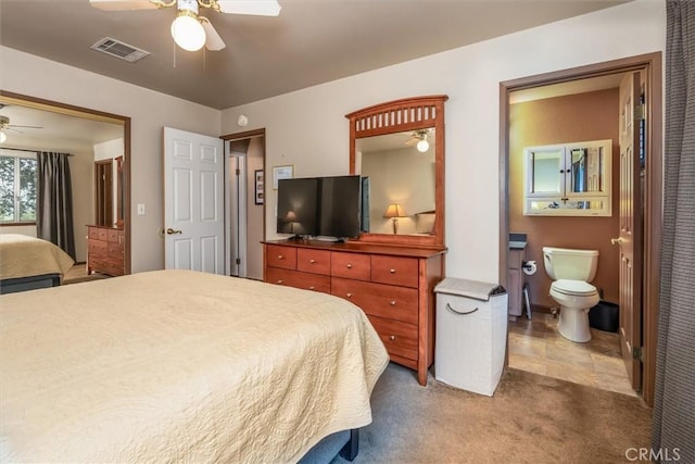 carpeted bedroom with ceiling fan, connected bathroom, and visible vents