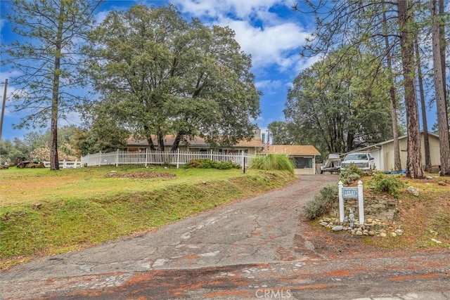 ranch-style house with driveway, a front yard, and fence