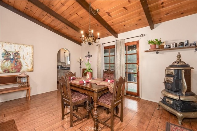 dining space with light wood-style flooring, arched walkways, wooden ceiling, and lofted ceiling with beams