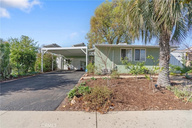 view of front of house featuring driveway, an attached carport, and stucco siding