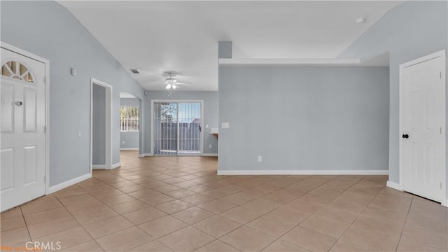 empty room with light tile patterned floors, arched walkways, visible vents, a ceiling fan, and baseboards