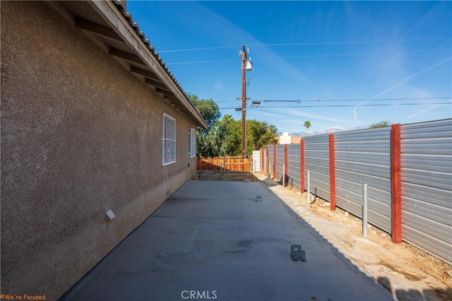 view of home's exterior with fence, a patio, and stucco siding