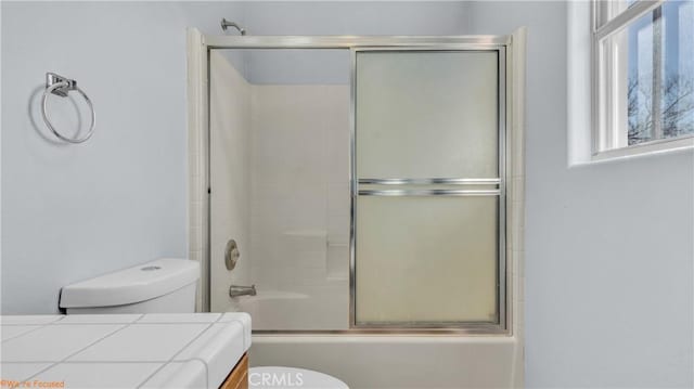 bathroom featuring enclosed tub / shower combo and toilet