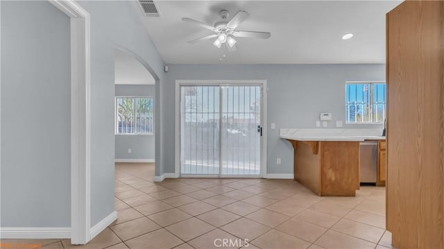 kitchen with light tile patterned floors, light countertops, visible vents, stainless steel dishwasher, and ceiling fan