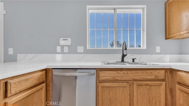 kitchen featuring a sink, plenty of natural light, light countertops, and dishwasher