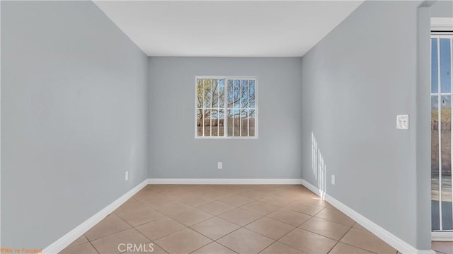 unfurnished room with baseboards and light tile patterned floors