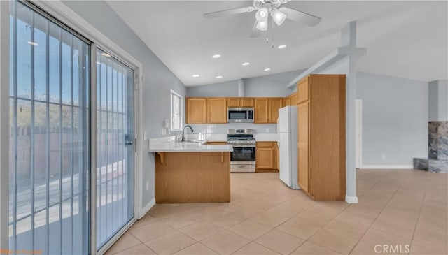 kitchen with stainless steel appliances, light countertops, vaulted ceiling, a sink, and a peninsula