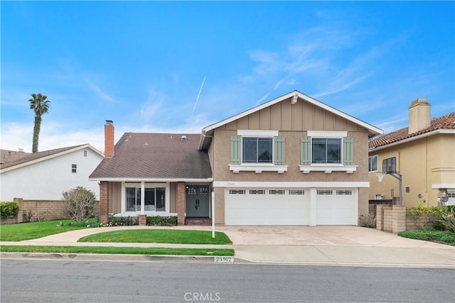 view of front facade with an attached garage, fence, concrete driveway, a front lawn, and board and batten siding