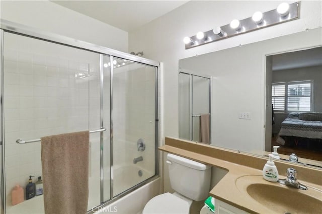 ensuite bathroom with toilet, shower / bath combination with glass door, ensuite bathroom, and vanity