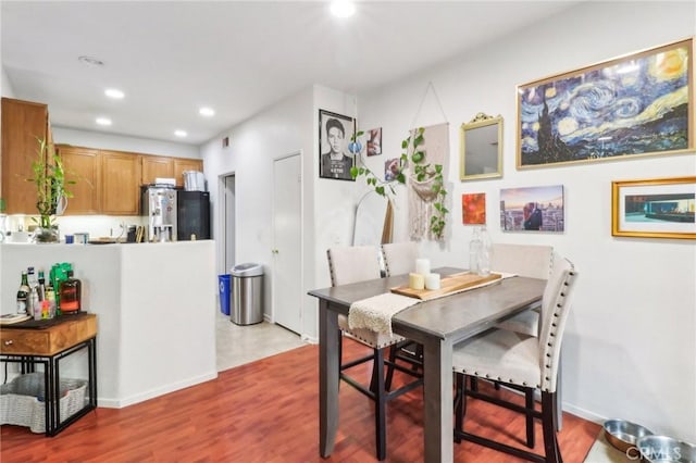 dining area featuring baseboards, wood finished floors, and recessed lighting