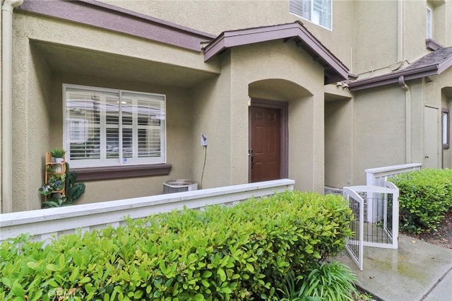 entrance to property with central AC and stucco siding