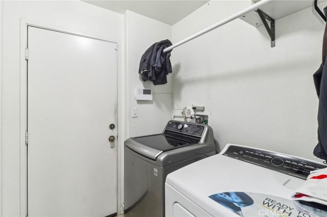 clothes washing area featuring laundry area and washer and clothes dryer