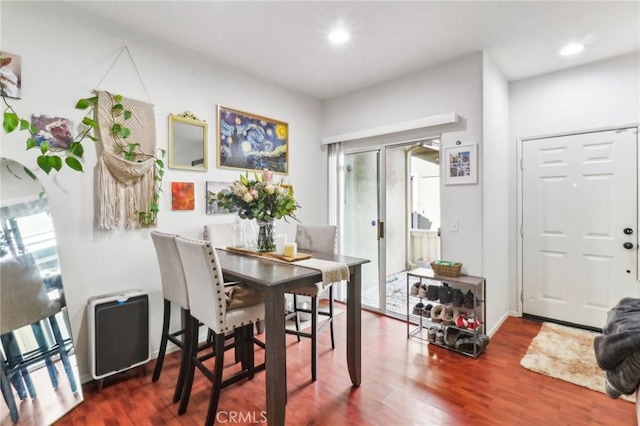 dining space with baseboards, wood finished floors, and recessed lighting