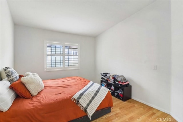 bedroom with baseboards and wood finished floors