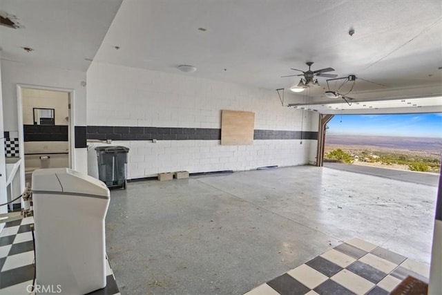 garage featuring a ceiling fan and concrete block wall