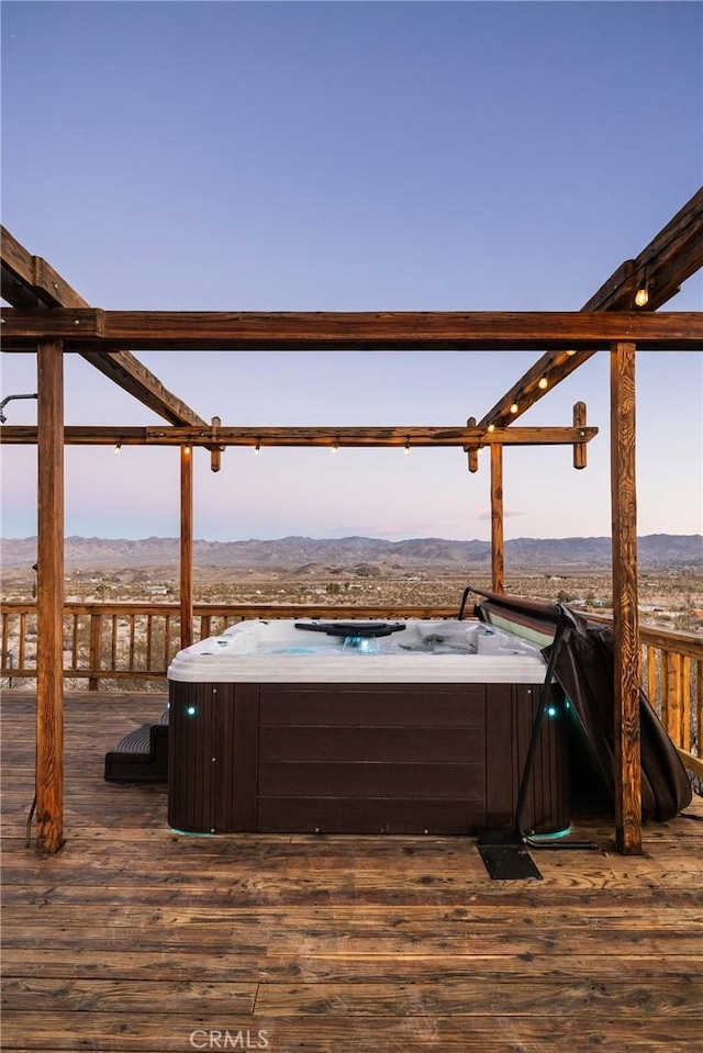 deck with a mountain view and a hot tub