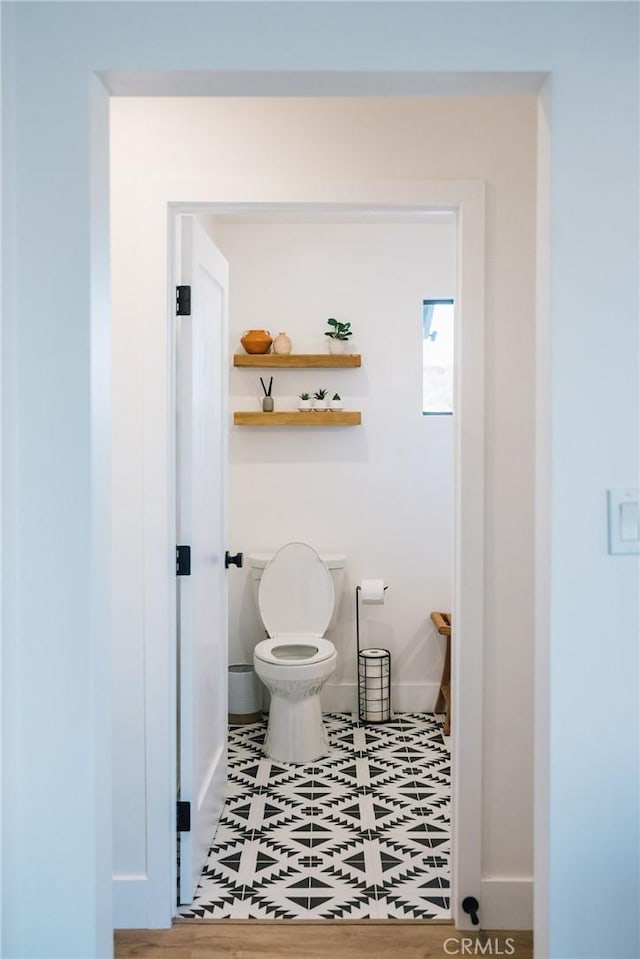 bathroom with toilet and baseboards