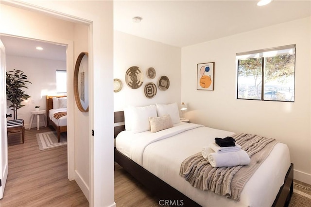 bedroom featuring light wood-style flooring, baseboards, and recessed lighting