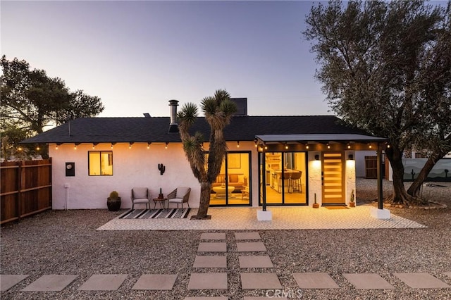 back of house featuring stucco siding, a patio, and fence